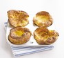 Four gluten-free Yorkshire puddings in a baking tray